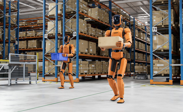 Zwei humanoide Roboter tragen Pakete in einer Werkshalle.