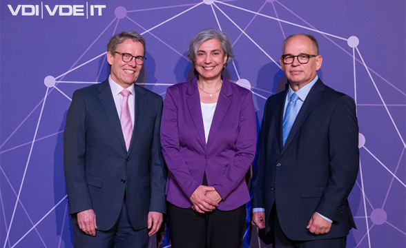 Zwei Männer und eine Frau lächeln in die Kamera