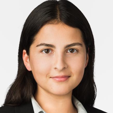 Frau mit dunklen, langen Haaren blickt in die Kamera