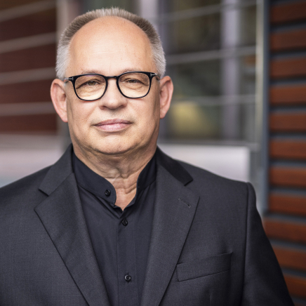 Ein Mann mit einer Brille schaut in die Kamera.