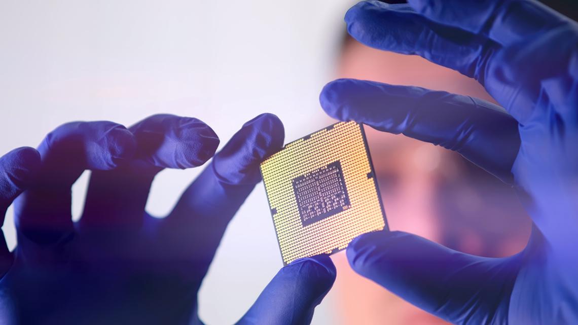 Zwei Hände halten einen Mikrochip