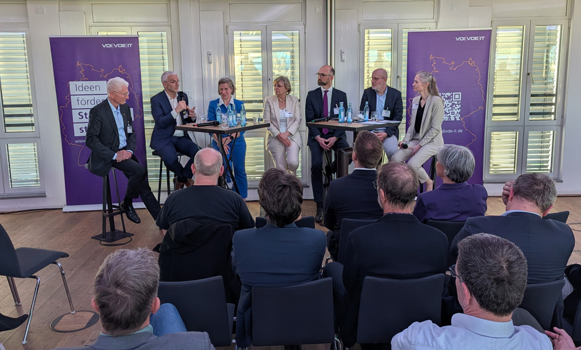 Frontalansicht Podiumsgäste bei Diskussion