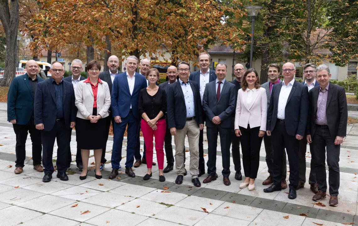Viele Männer und Frauen stehen für ein Gruppenbild nebeneinander.