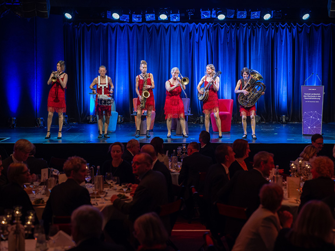 Sechs Frauen stehen auf einer Bühne und machen Instrumentalmusik.
