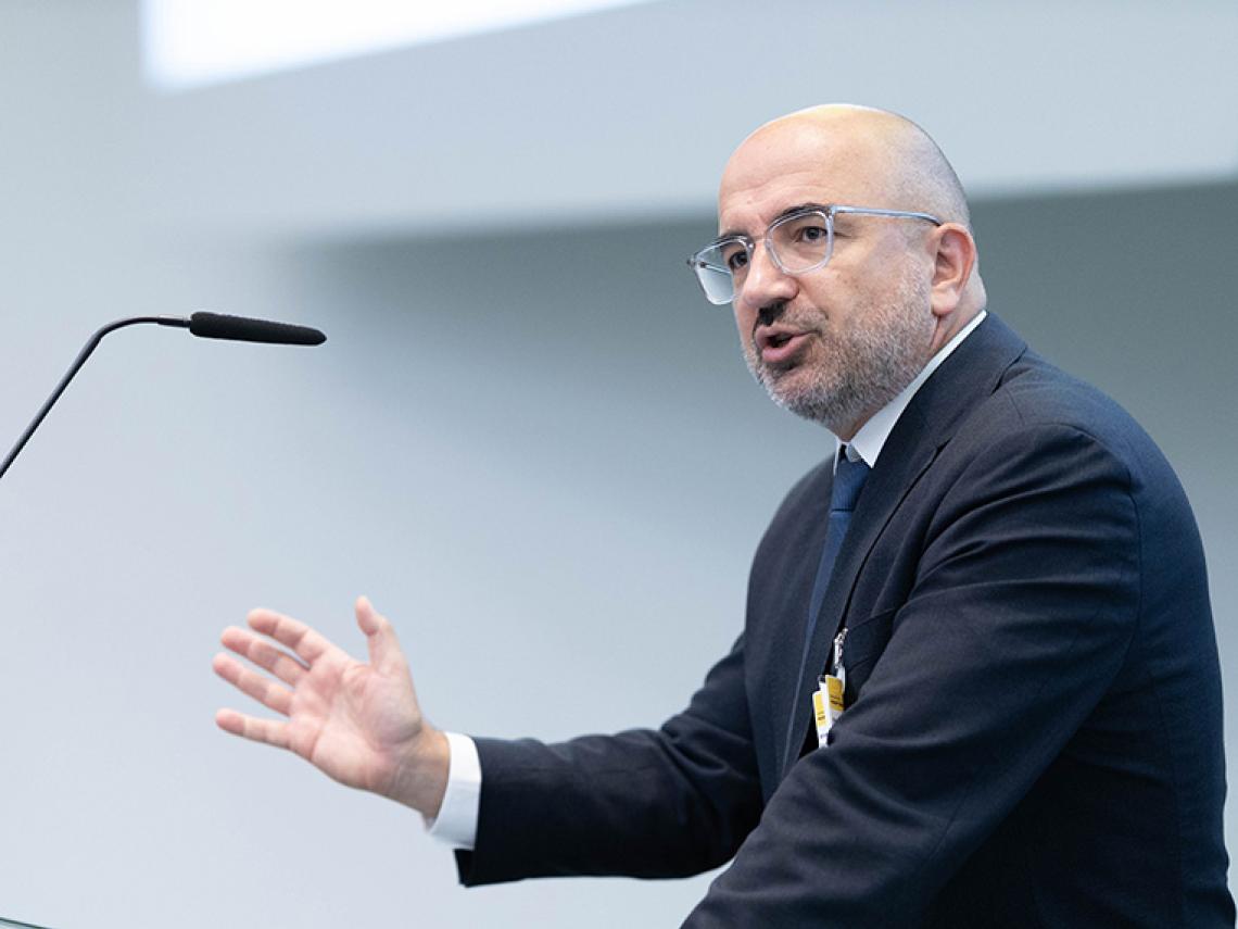 Ein Mann steht an einem Redepult und spricht.