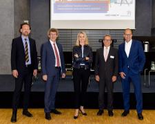 Fünf Menschen stehen nebeneinander und sehen in die Kamera