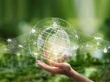 Hand hält eine Weltkugel, die von verschiedenen Icons umgeben ist.