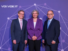 Zwei Männer und eine Frau lächeln in die Kamera